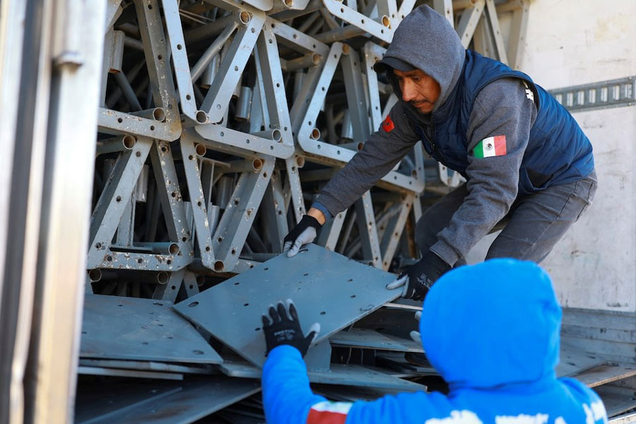 Workers unload construction materials from a trailer, where Mexican authorities will build a temporary shelter for migrants deported from the United States, in Ciudad Juarez, Mexico, January 21, 2025.