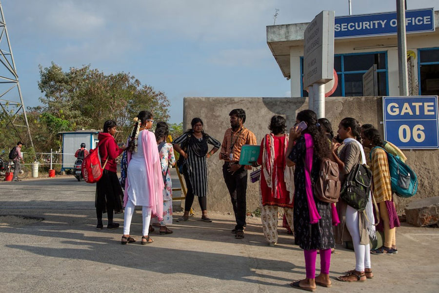 Job aspirants talk with a hiring agent outside the Foxconn factory, where workers assemble iPhones for Apple, in Sriperumbudur, near Chennai, India, April 1, 2024.