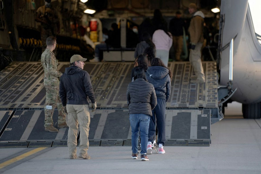 US Customs and Border Protection security agents guide a group of detained migrants to board a US Air Force C-17 Globemaster III aircraft for a removal flight at Fort Bliss, Texas, US, January 23, 2025.