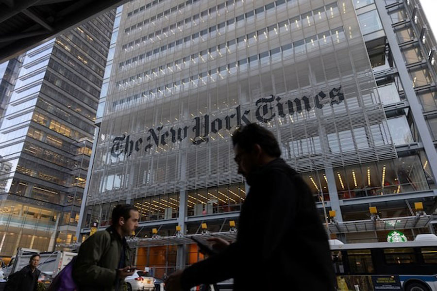 Pedestrians walk by the New York Times building in Manhattan, New York, US, December 8, 2022.