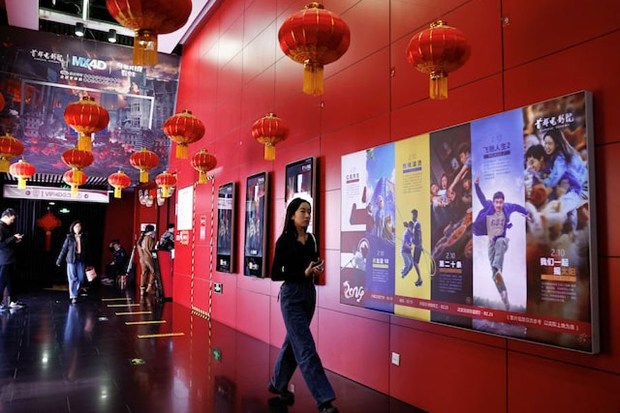 A person walks past movie posters at the Capital Cinema in Beijing, China February 21, 2024.