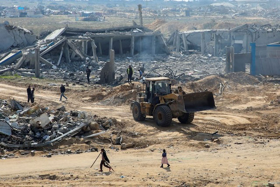 A Palestinian man operates heavy machinery to open the road and remove the rubble, amid a ceasefire between Israel and Hamas, in the southern Gaza Strip, February 4, 2025.