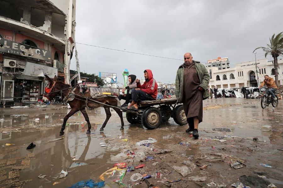 Palestinians make their way along a road on a rainy day, amid a ceasefire between Israel and Hamas, in Gaza City February 6, 2025.