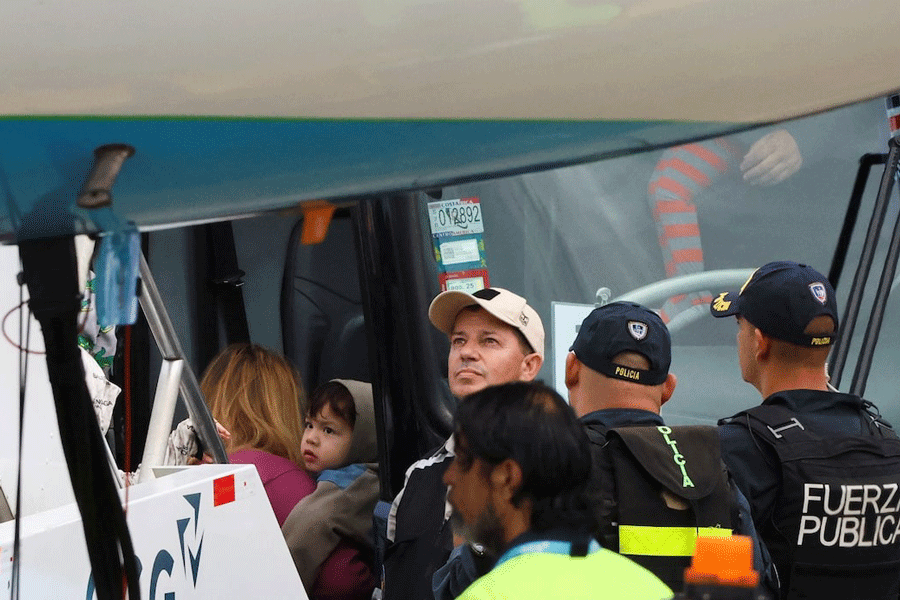 A child and other migrants board a bus after arriving in Costa Rica on a deportation flight from the US before being sent to their home countries, at Juan Santamaría Airport, in Alajuela, Costa Rica February 20, 2025.