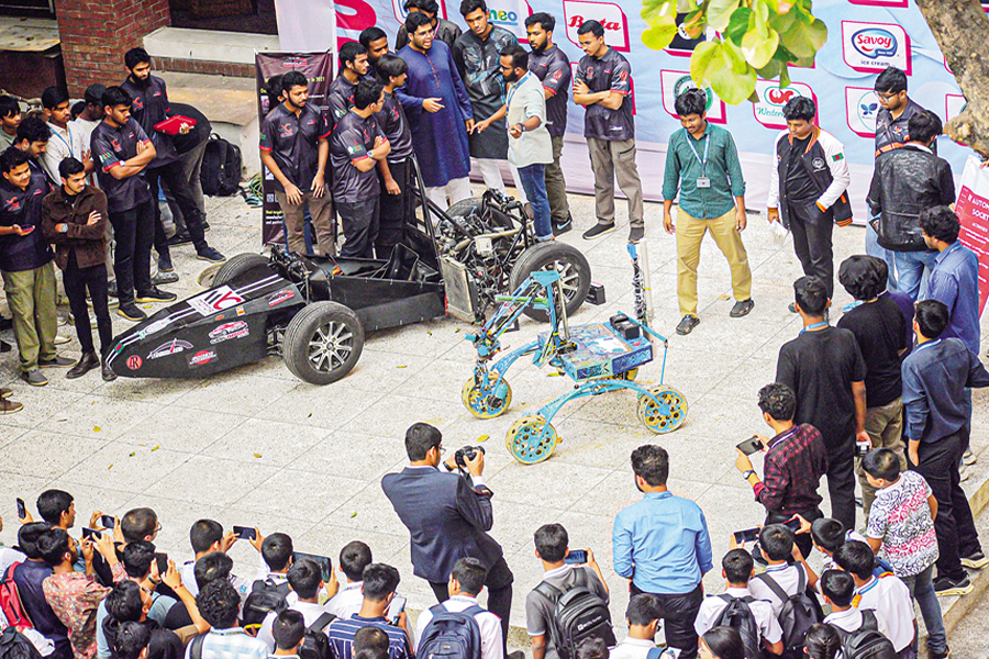 Team members of formula IUT project displaying the engine of their formula student car at 8th National Earth and Space Summit held at Notre Dame College, Dhaka recently