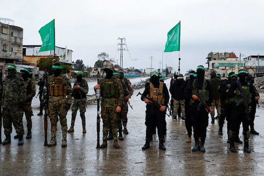Palestinian Hamas militants stand guard on the day of the handover of hostages, including those held in Gaza since the deadly October 7 2023 attack, to members of the International Committee of the Red Cross (ICRC) as part of a ceasefire and a hostages-prisoners swap deal between Hamas and Israel, in Rafah in the southern Gaza Strip, February 22, 2025.