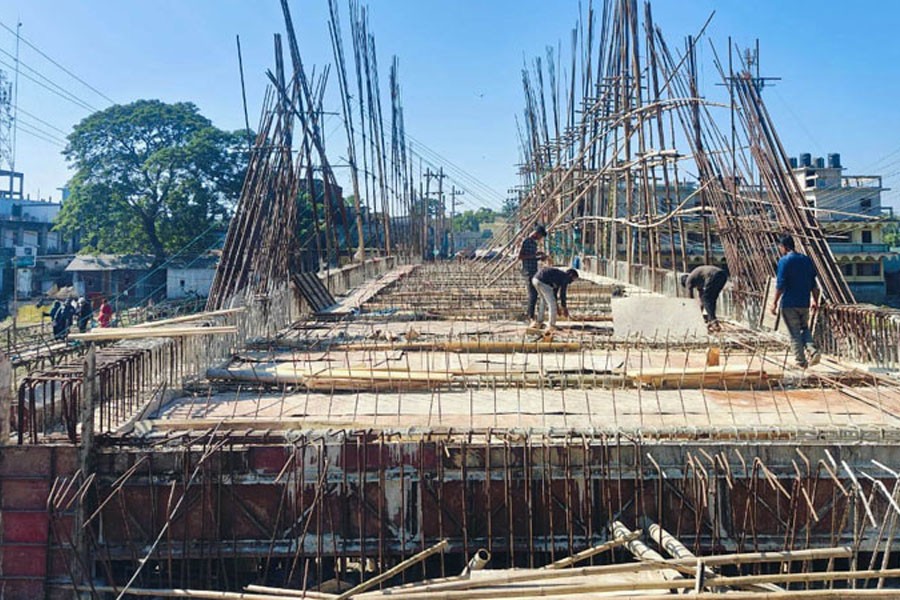 Photo shows workers passing busy time at the site of an under-construction bridge in Jagannathpur upazila of Sunamganj district