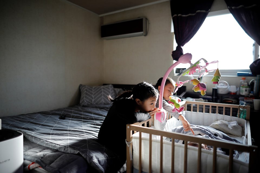 Girls take care of their baby brother before leaving for school, at their home in Seoul, South Korea on December 19, 2018 — Reuters/File
