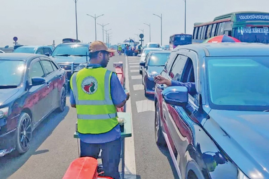 An employee collecting toll from the vehicles, stuck in a gridlock at Tejgaon portion of the Dhaka Elevated Expressway in the capital on Sunday. — Focus Bangla