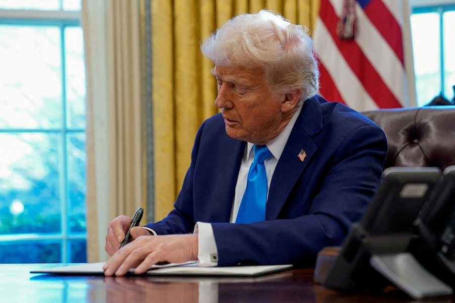 US President Donald Trump signs a document in the Oval Office at the White House in Washington, US, February 4, 2025.