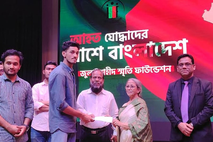 Fisheries and Livestock Adviser Farida Akhter giving cheques to persons with injuries student-led mass upsurge at Khulna Shilpokola Academy on Sunday.