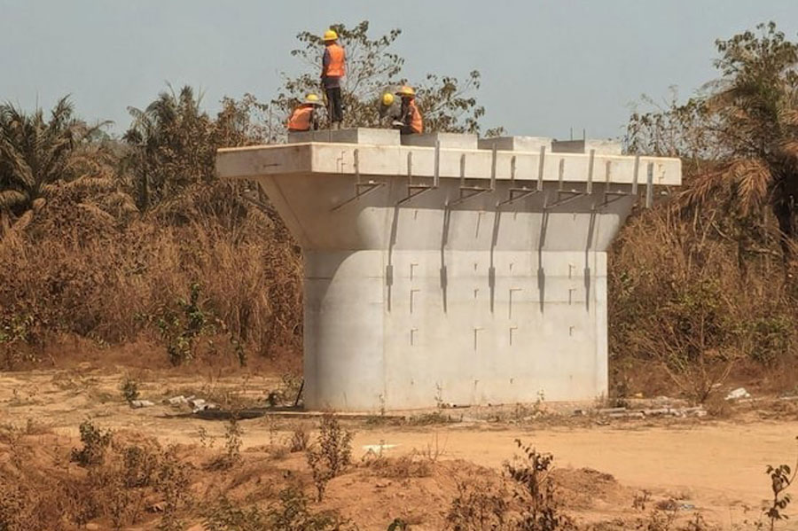 Local workers sit on a rail support column along the Simandou rail corridor, Guinea, in March 2024.