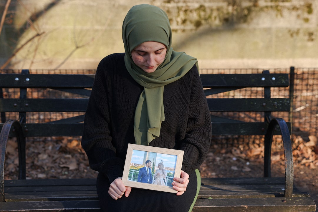 Noor Abdalla, 28, wife of Palestinian activist and Columbia University graduate student Mahmoud Khalil who was detained by ICE, sits for a portrait holding a photograph of their wedding day after an interview with Reuters in New York City, U.S., March 12, 2025. REUTERS/Caitlin Ochs