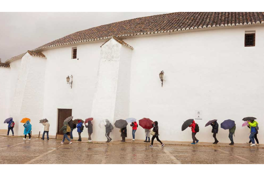 Tourists use umbrellas to cover themselves from a heavy rain and high winds, while they tour the city centre outside the bullring, as storm Konrad hits Spain, Portugal and France, in Ronda, Spain, Mar 13, 2025.