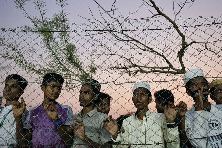 Rohingya refugees look through a wire fence as they attend a Ramadan Solidarity Iftar to have an Iftar meal with United Nations Secretary-General Antonio Guterres and Muhammad Yunus, Chief Adviser of the Bangladesh Interim Government, at the Rohingya refugee camp in Cox’s Bazar, Bangladesh, Mar 14, 2025.