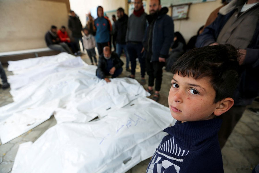 A child looks on as people mourn Palestinians killed in Israeli strikes, at the European hospital in Khan Younis in the southern Gaza Strip March 20, 2025.