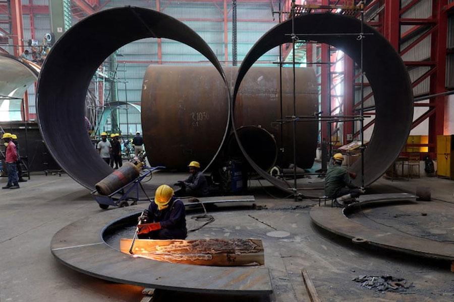 A worker cuts a metal plate inside an industrial tank manufacturing factory on the outskirts of Ahmedabad, India, January 31, 2025.