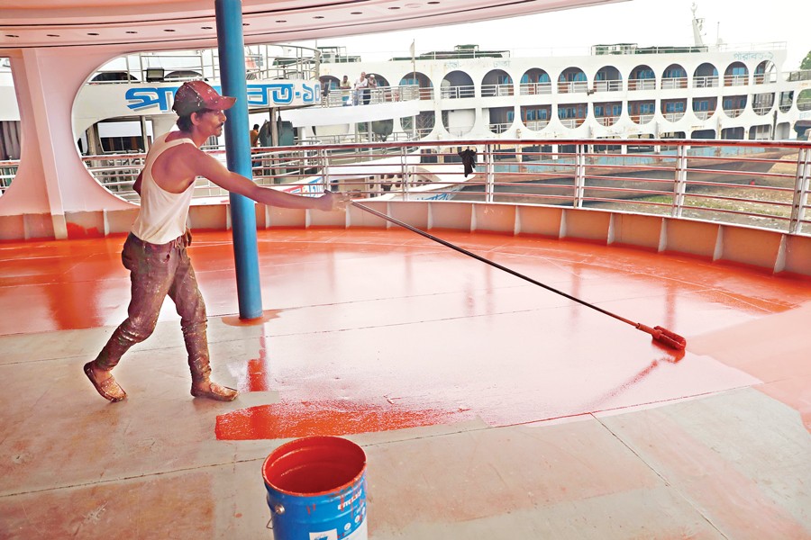 A worker is busy painting the deck of a launch at a dockyard in Keraniganj. Refurbishment work gathers pace several days ahead of each Eid as people in large numbers leave for their home villages to celebrate the festival with their loved ones. The photo was shot on Sunday