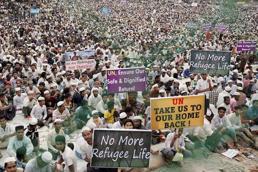 Rohingya refugees hold placards while attending a Ramadan Solidarity Iftar to have an Iftar meal with United Nations Secretary-General Antonio Guterres and Muhammad Yunus, Chief Adviser of Bangladesh Interim Government, at the Rohingya refugee camp in Cox's Bazar, Bangladesh, March 14, 2025.