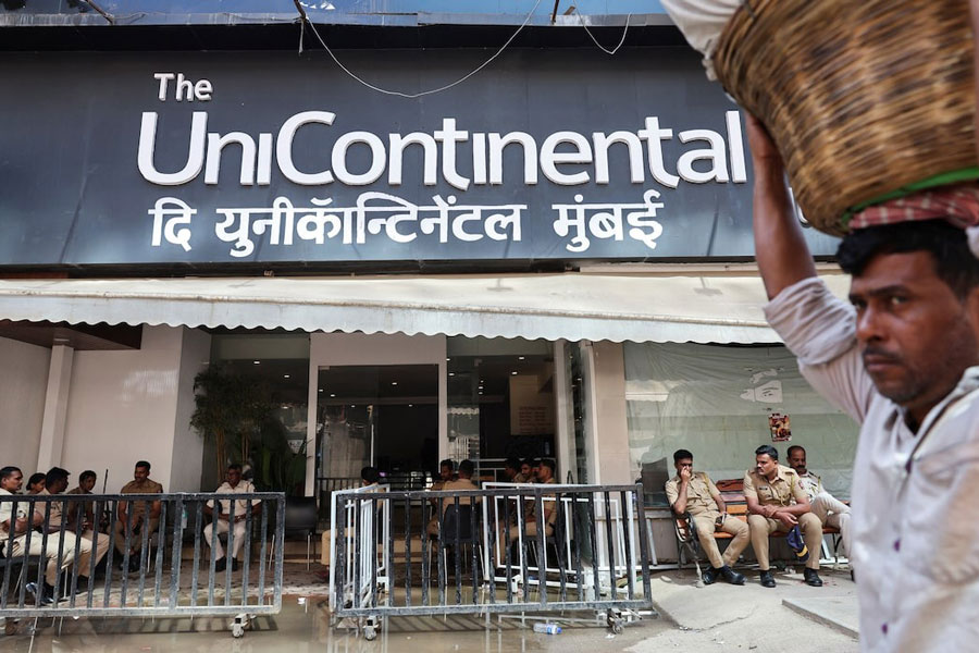 Police officers sit outside The Habitat, a studio where Kunal Kamra, a stand-up comedian, performed following which the studio was ransacked by the supporters of Eknath Shinde, Deputy Chief Minister of Maharashtra, in Mumbai, India, March 26, 2025.