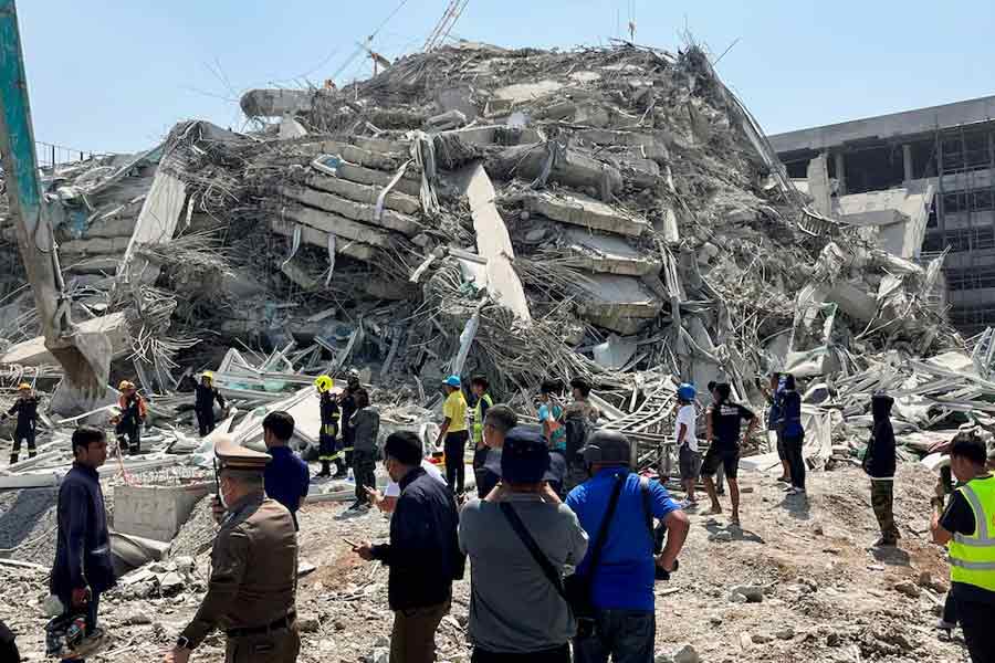 People standing near the site of a collapsed building in Bangkok, Thailand after a powerful earthquake on Friday –Reuters photo
