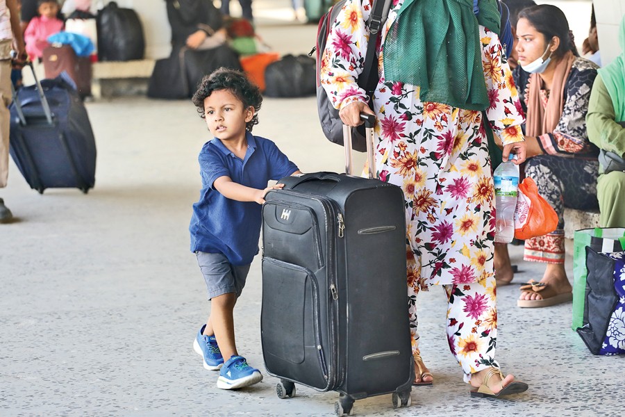The snap shows a tiny tot walking along with his mother at the Kamalapur Railway Station on Friday as people are leaving Dhaka in their thousands. Trains bound for different destinations run on schedule this Eid — FE Photo by Shafiqul Alam