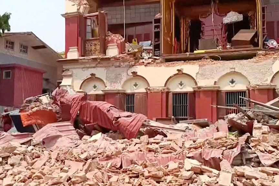 People stand near a collapsed temple following an earthquake in Mandalay, Myanmar, March 28, 2025, in this screengrab taken from a social media video.
