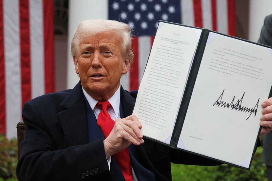 US President Donald Trump holds a signed executive order on tariffs, in the Rose Garden at the White House in Washington, DC, US, Apr 2, 2025. REUTERS
