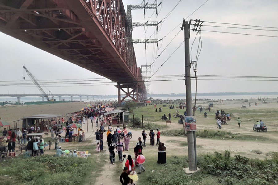 Visitors in their multitudes gathered on the Lalon Shah Bridge under the Hardinge Bridge at the Pakshi Railway Station to see the four cooling towers of the Rooppur Nuclear Power Project
