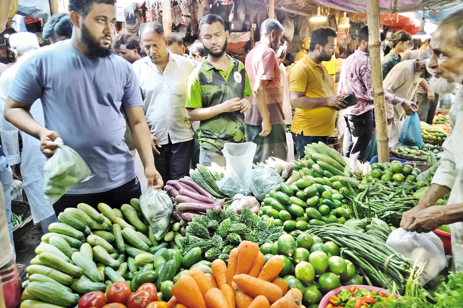 Consumers buy vegetables at a kitchen market at Nayabazar in the capital on Friday. — FE Photo