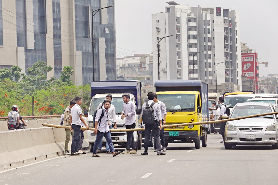 Students from various polytechnic institutes stage protests in different places in Dhaka and other parts of the country to press their six-point demand, including recognition of their diplomas as equivalent to undergraduate degrees. In the picture taken at the Moghbazar Flyover on Wednesday, some students place a pole across the road to block traffic. — FE Photo