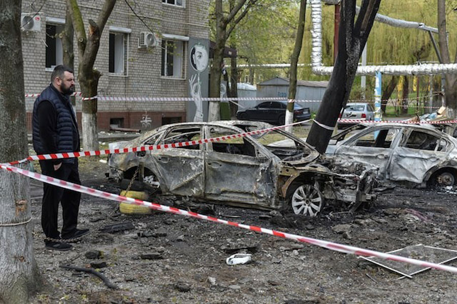 A resident stands next to burned cars at the site of a Russian drone strike, amid Russia's attack on Ukraine, in Dnipro, Ukraine April 17, 2025.