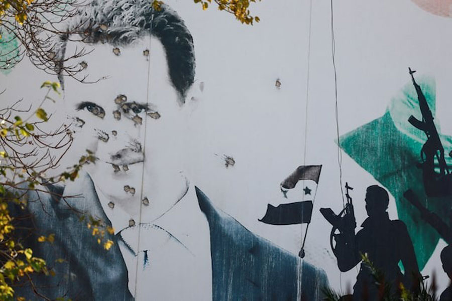 A billboard with a picture of Syria's Bashar al-Assad shows damage by bullet holes, after the ousting of Syria's Bashar al-Assad, in Damascus, Syria, December 16, 2024.