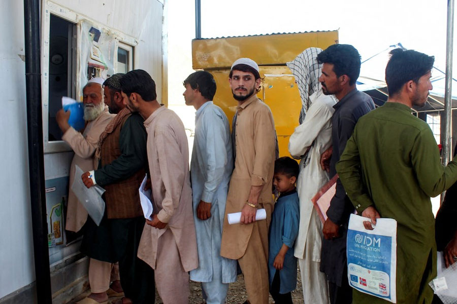Afghan nationals, who were expelled from Pakistan, stand in queue for registration upon their arrival at the Omari refugee camp in Mohmand Dara, Torkham border, Nangarhar province, Afghanistan, April 15, 2025.