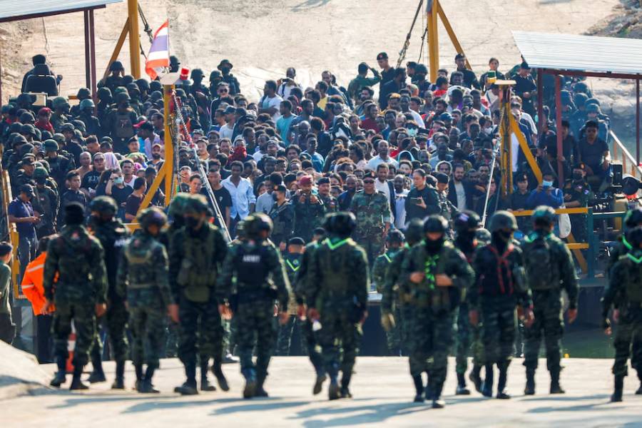 Multinational victims of scam centers, who were tricked or trafficked into working in Myanmar, stand on a vessel floating towards the Thai side of border via Moei River in Phop Phra District, Tak province, Thailand February 12, 2025.