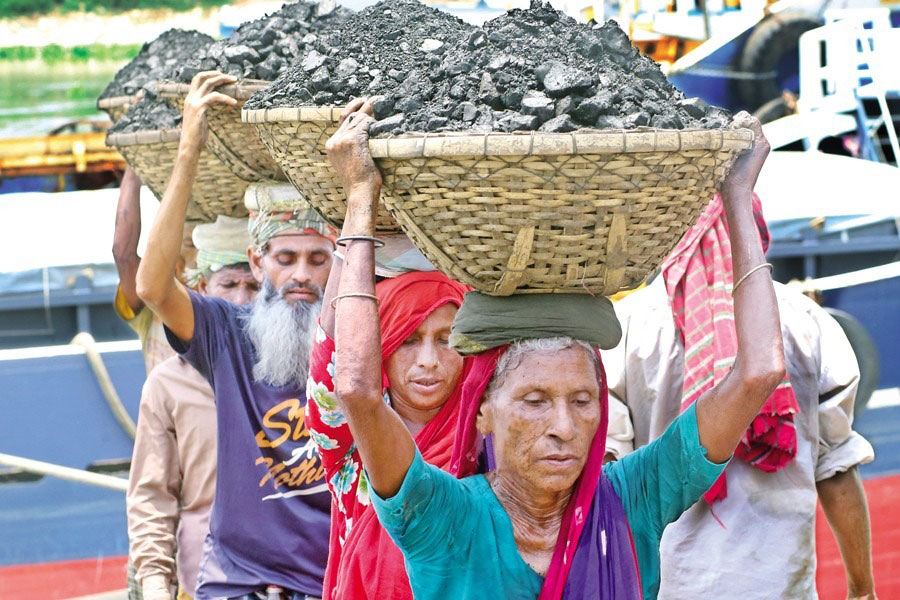 Elderly workers are busy unloading coal from a ship onto a truck, not in frame, in Dhaka's Gabtoli area on Sunday, April 30, 2023.