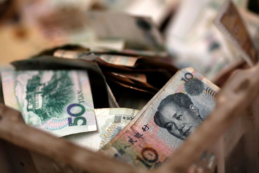 Chinese banknotes are seen at a vendor's cash box at a market in Beijing February 14, 2014.
