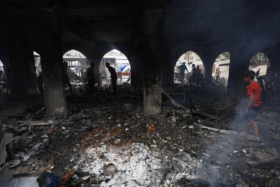 Palestinians inspect the damage at a school sheltering displaced people, following an Israeli strike, in Gaza City, April 23, 2025.