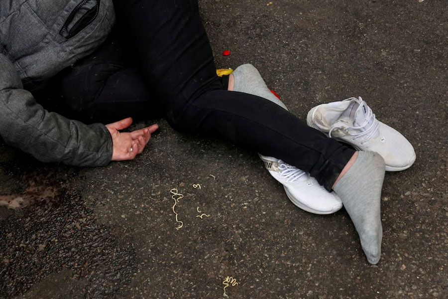 A man who has passed out lies in a parking lot in the Kensington area of Philadelphia, Pennsylvania, US, March 26, 2025.
