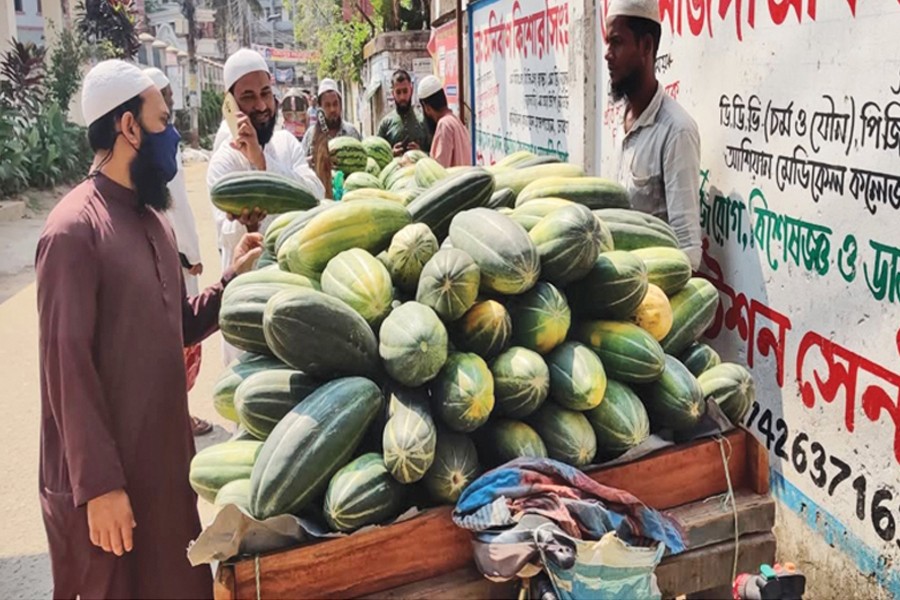 A vendor selling muskmelon from a rickshaw van at Biponibagh Bazar in Chandpur town