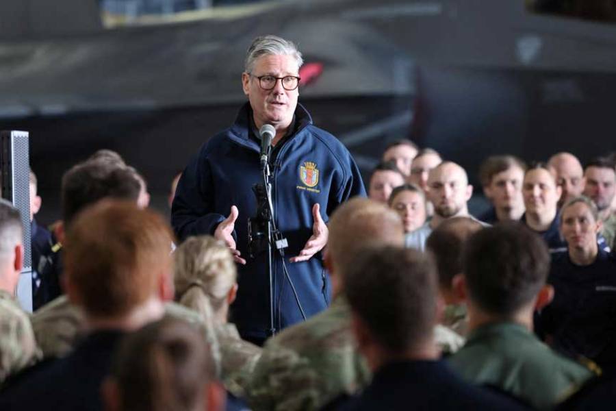 British Prime Minister Keir Starmer addresses the crew of the British aircraft carrier HMS Prince of Wales in front of an F35 fighter aircraft in the hangar of the carrier, which is on an eight-month operational deployment.
