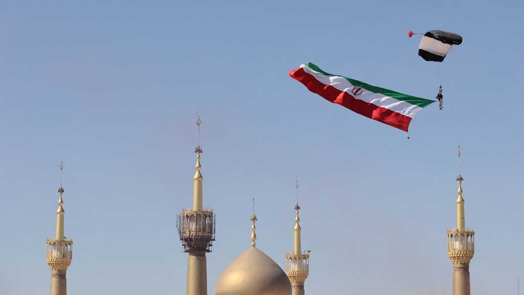 A paratrooper carries the Iranian flag over the shrine of Iran's late leader Ayatollah Ruhollah Khomeini during the National Army Day parade ceremony in Tehran, Iran, Apr 18, 2025.