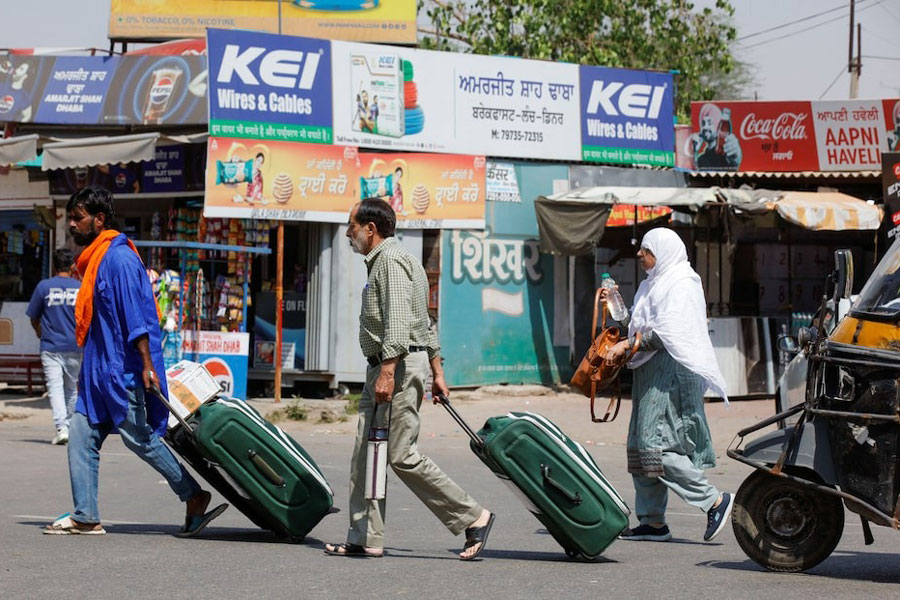 People carry baggage as they travel towards the Attari-Wagah crossing on the India-Pakistan border near Amritsar, following Tuesday’s attack on tourists near south Kashmir’s scenic Pahalgam, India, April 25, 2025.