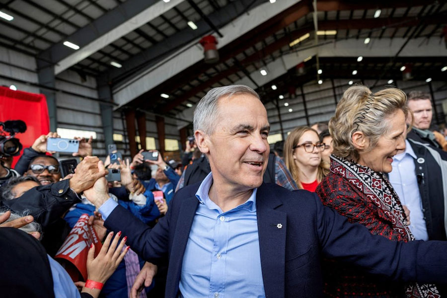 Canada's Prime Minister Mark Carney interacts with supporters, next to his wife Diana Fox Carney, at a rally in a Pearson International Airport hangar, during his Liberal Party election campaign tour in Mississauga, Ontario, Canada April 26, 2025.