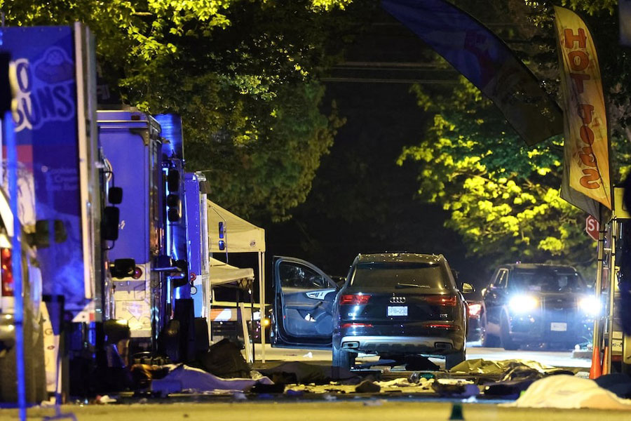 The suspect vehicle is seen with the driver's door open, as bodies of victims lie covered on the ground, after it drove into a crowd at a Lapu Lapu day block party, in which police say multiple people were killed and injured, in Vancouver, Canada April 27, 2025.