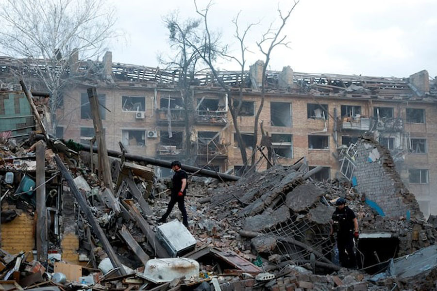 Police officers inspect the site of a building hit by a Russian ballistic missile strike, amid Russia's attack on Ukraine, in Kyiv, Ukraine April 24, 2025.