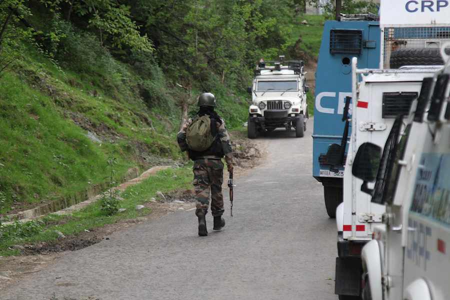 An Indian security force trooper moves past parked vehicles during a cordon and search operation, following an attack on tourists near Pahalgam, in Gudder village of south Kashmir's Kulgam district April 26, 2025.