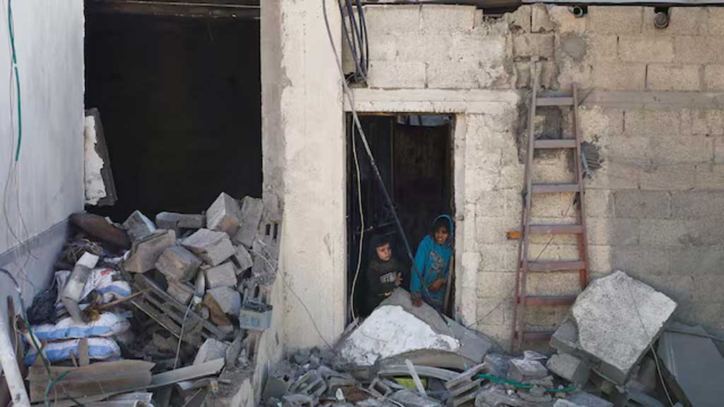 Palestinian kids stand at the site of an Israeli strike on a house, amid the ongoing conflict between Israel and the Palestinian Islamist group Hamas, in Rafah in the southern Gaza Strip, February 7, 2024. REUTERS/Ibraheem Abu Mustafa