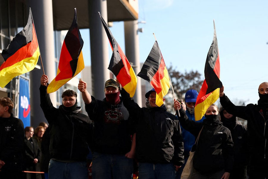 Supporters of the Alternative for Germany party (AfD) wave flags as they take part in an AfD campaign rally in Hohenschoenhausen, Berlin, Germany, February 22, 2025.