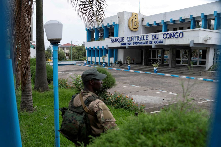 A member of the M23 rebel group stands guard at Congo's Central Bank, which has been closed since Goma was taken by M23 rebels, where all banks have closed, in Goma, North Kivu province in the East of the Democratic Republic of Congo, April 7, 2025.